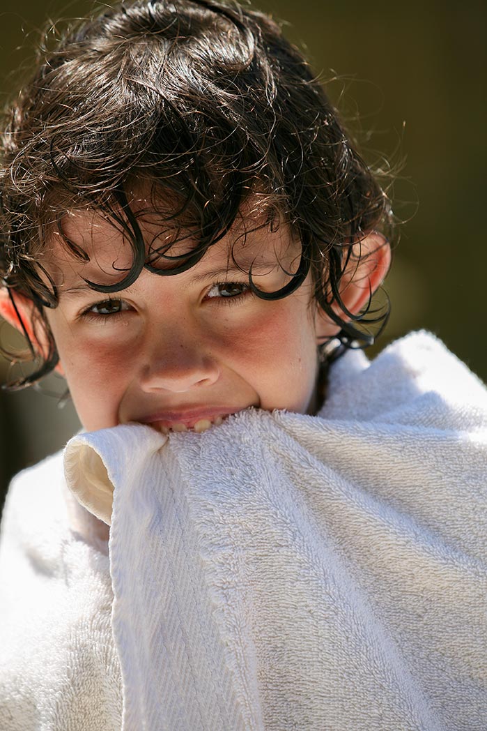 Boy covered in white towel